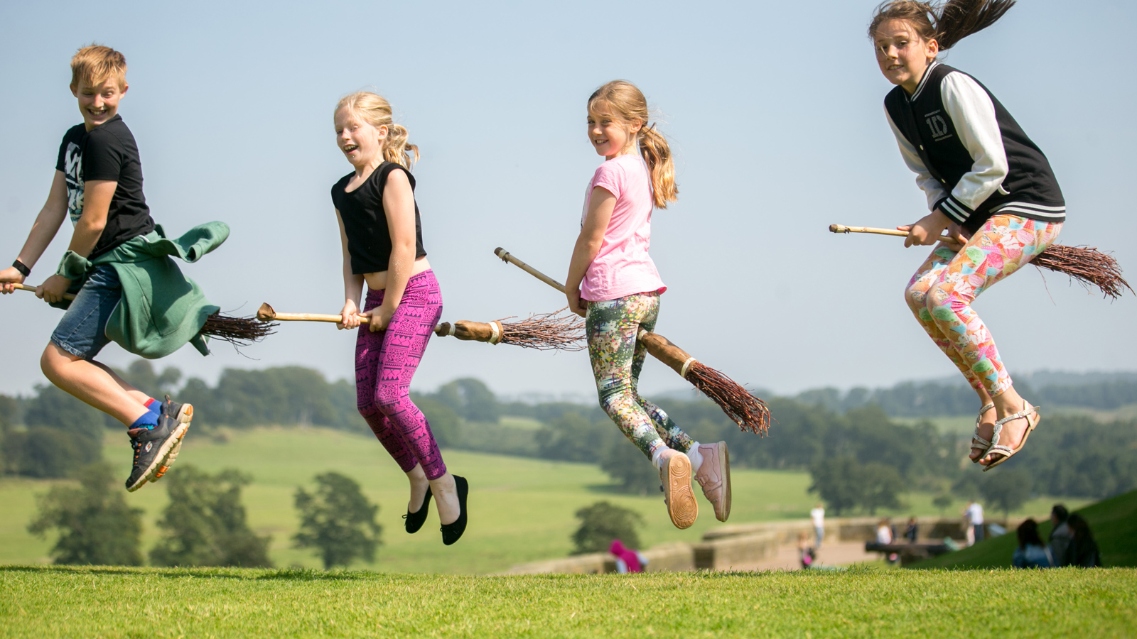 4 kids on broomsticks